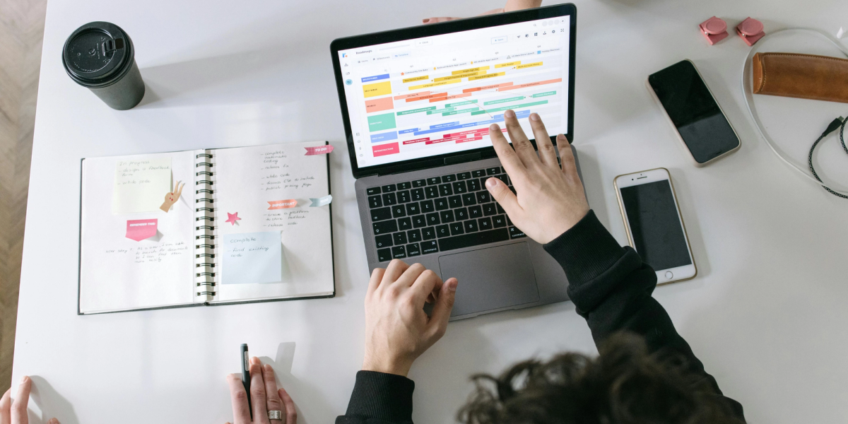 Personne devant un ordinateur Mac avec un planning Google Agenda affiché à l’écran